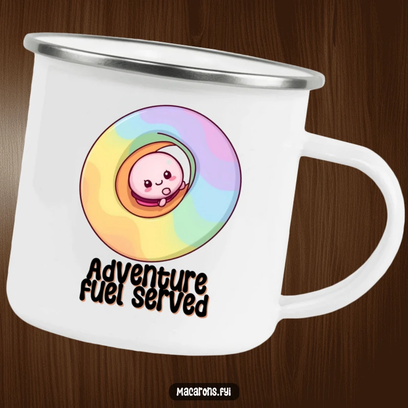 Funny macaron character sliding down a colorful rainbow swirl on a durable camping mug, ready for outdoor fun.