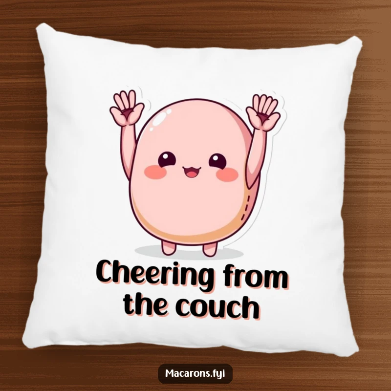 Funny macaron character joyfully cheering with tiny hands raised high, featured on a soft pillow.