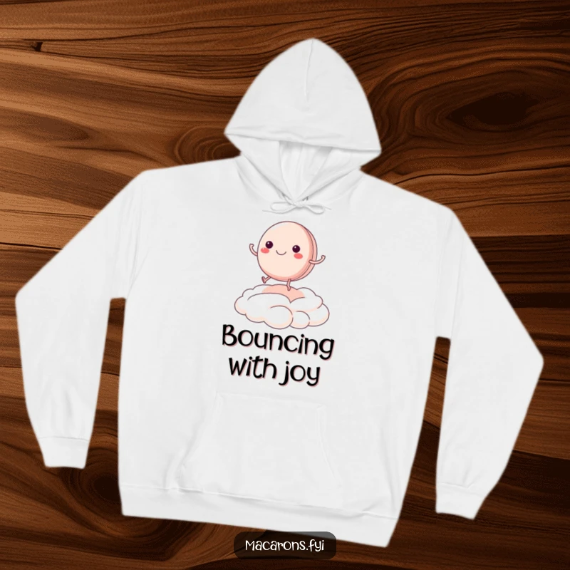 Funny macaron character with legs kicking, bouncing joyfully on a cream cloud, featured on a soft hoodie.