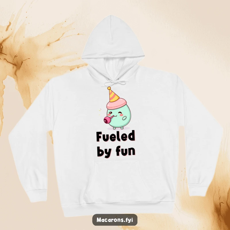 Funny macaron character with party hat blowing a tiny party blower, depicted on a cozy hoodie, spreading happiness.