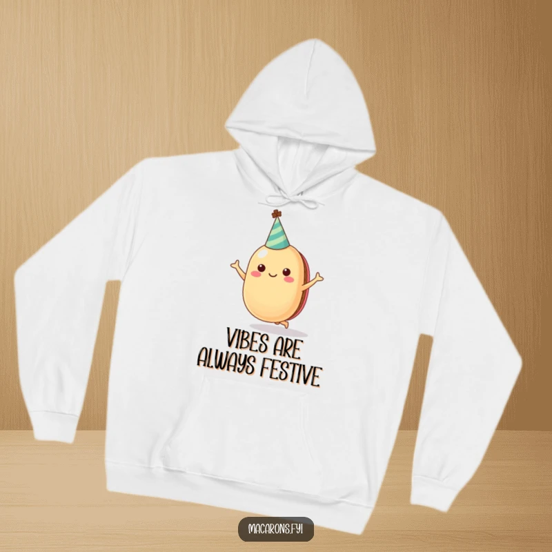 Funny, cozy hoodie featuring a cheerful macaron character in a party hat, captured in a dynamic jumping pose for ultimate fun.