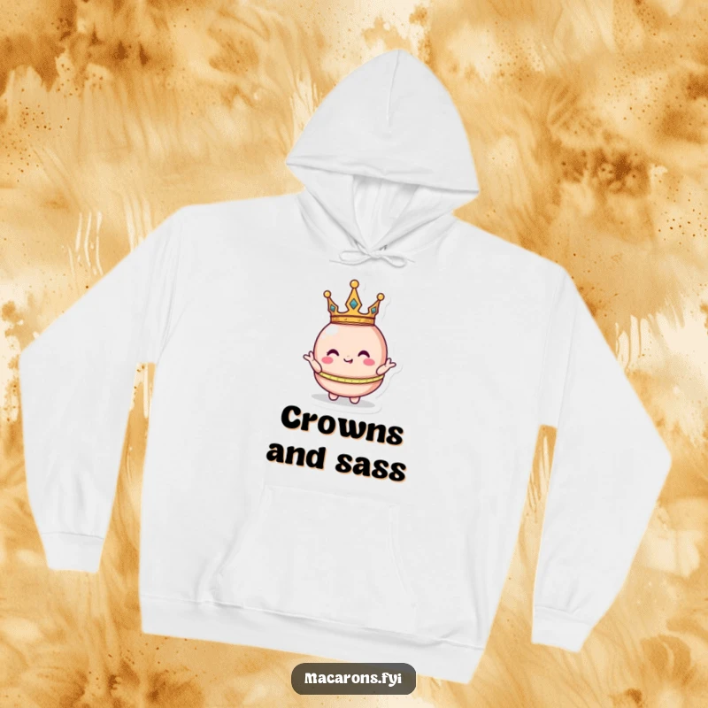 Plush funny macaron character wearing a tiny crown, striking a silly royal pose on a warm hoodie for regal comfort.