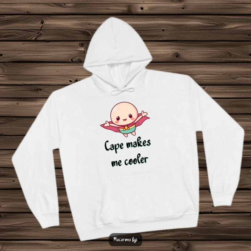 Funny macaron hoodie showing a determined macaron character in a cape, ready to fly and conquer with sugary bravery.