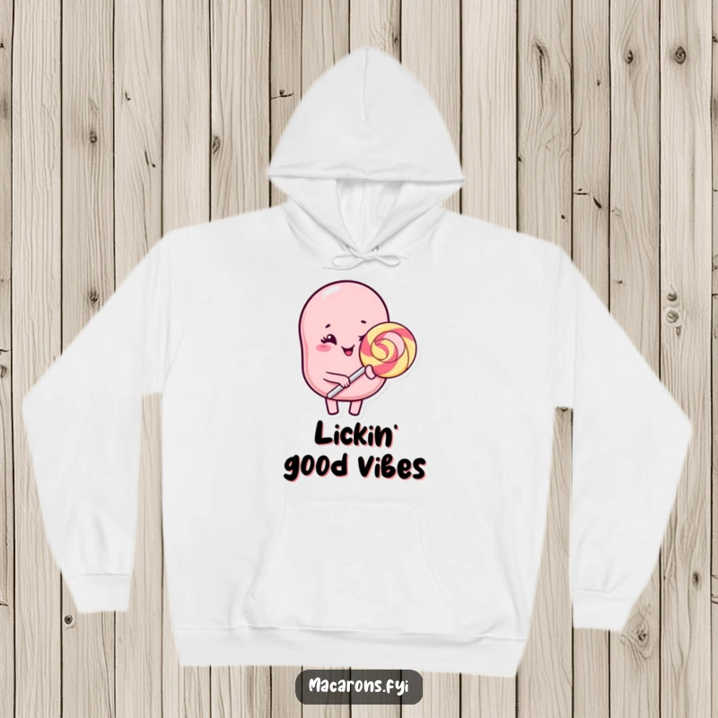 Funny Kawaii macaron character winking with a giant lollipop, offering warmth and humor on this comfy hoodie.