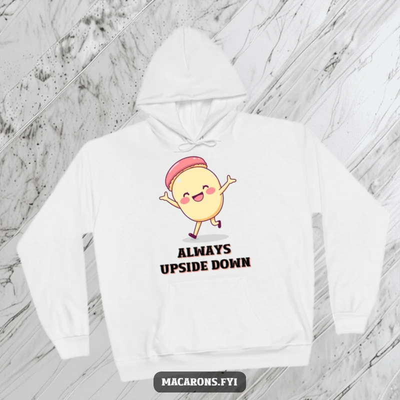 Funny macaron character doing a cartwheel with a big grin, featured on a cozy hoodie, symbolizing playful energy.