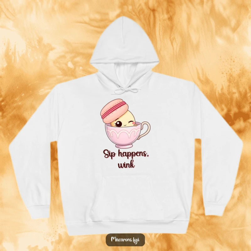 Funny macaron character peeking from behind a giant teacup, offering a wink, featured on a soft hoodie.