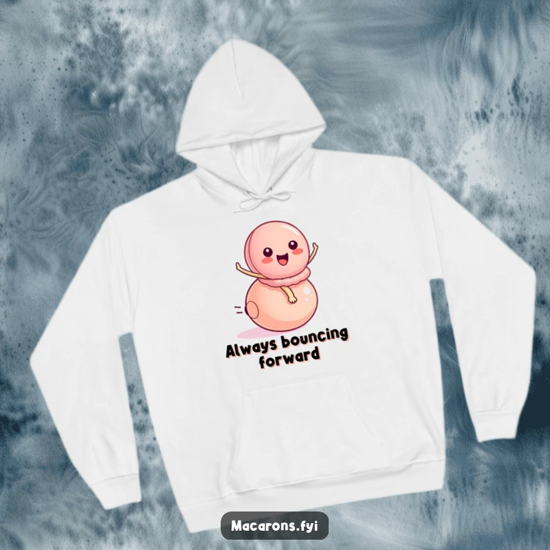 Funny peppy macaron character energetically riding a small bouncy ball, designed for cozy comfort in this stylish hoodie.