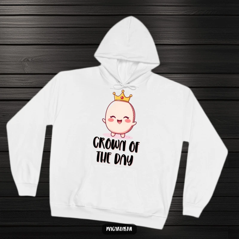Funny macaron character wearing a tiny crown and giggling, depicted in regal fashion on a cozy, comfortable hoodie.