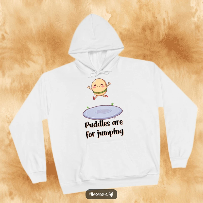 Funny hoodie with a single macaron character leaping joyfully over a tiny puddle, offering cozy inspiration.