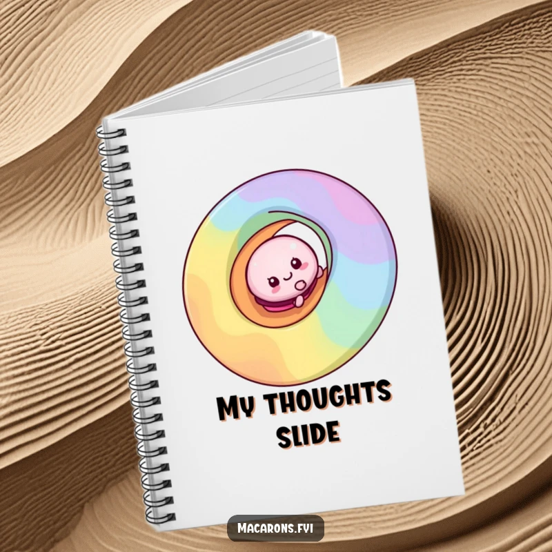 Funny macaron character sliding down a vibrant rainbow swirl on the cover of a lined notebook for creative writing.