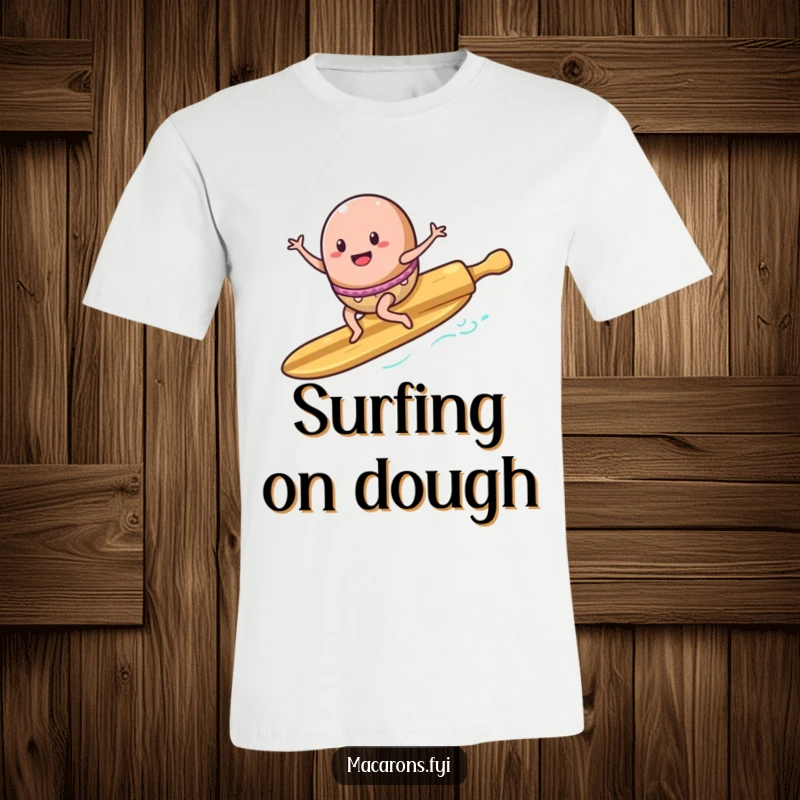 Funny T-Shirt: A macaron character surfs enthusiastically on a rolling pin, depicted as a surfboard, exuding playful energy.
